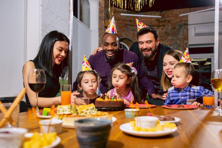 Happy family gets together to celebrate a birthday at home while eating a birthday cake.